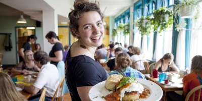 Server holding breakfast on a plate