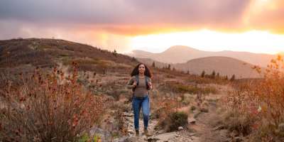 Hiker on top of Black Balsam during sunset with fall colors