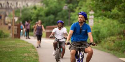 Two men riding bikes along the greenway in Asheville