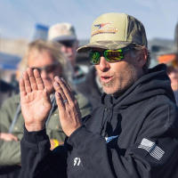 Pilot Kevin Quinn in flight gear smiling and clapping.
