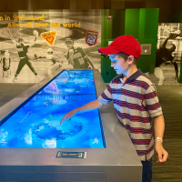Picture of young boy interacting with display at World of Little League Museum