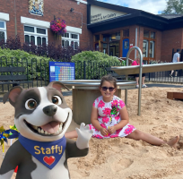 Staffy with a child playing in the sand and posing outside the Brampton Museum