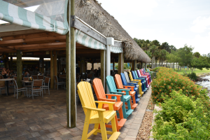 Line of colorful chairs outside Lighthouse Grill at Stump Pass, facing Lemon Bay