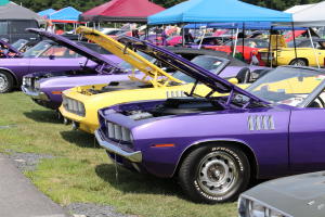 Line of muscle cars with hoods up at the Carlisle Chrysler Nationals