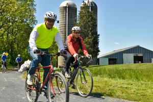 Friends ride their bikes along the Cumberland Valley Rail Trail on a clear spring day.