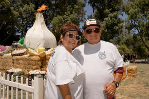 A couple poses for a photo in front of the Garlic Festival Torch