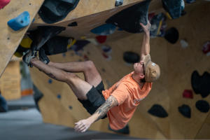 Climber hanging in arch while bouldering at the Greeley Climbing Collective