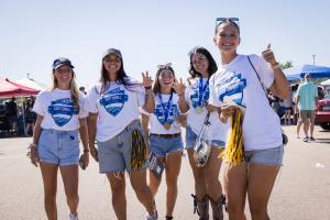 Five students posing for a photo at the UNC Homecoming Tailgate