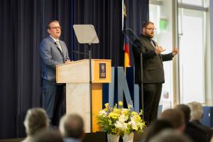 Andy Feinstein, with an ASL interpreter, is delivering the state of the university address