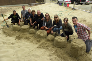 The Eugene, Cascades & Coast staff proudly shows their sand creations, with animals, sports themes, and more