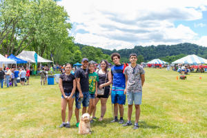 Group of people having fun at the spring fiesta with their small dog