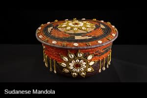 A Sudanese Mandola, which is a woven basket with decorative shells and beads.