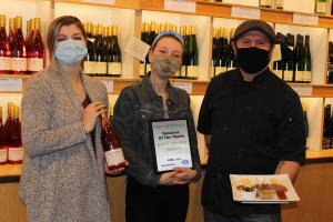 Staff Pose in the Tasting Room of Sheldrake Point Winery holding the Plaque awarding them the April 2021 Business of the Month