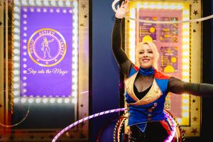 A performer with two hula hoops, one above her head and the other around her waist, prepares to entertain you outside The Philip Astley Centre, Newcastle-under-Lyme, Staffordshire