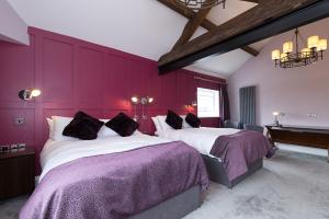 A bedroom with period features including oak beams, and luxurious furnishings, at The Little George, Eccleshall, Staffordshire