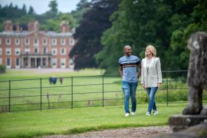 couple walking the grounds with the House in the background