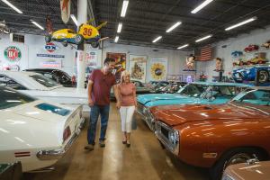 A couple examines the gleaming cars at Fast Lane Classic Cars in St. Charles, MO