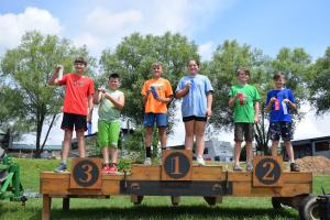 Picture of contest winners standing on podiums with winning ribbons at the Nittany Mountain / South Williamsport KOA
