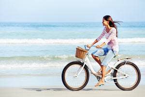 Woman biking on beach