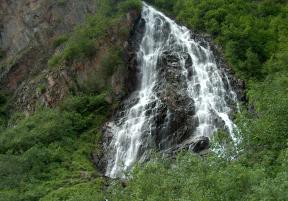 a waterfall in a lush canyon