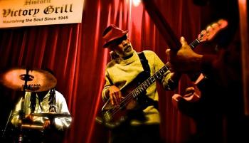 Harold McMillan playing guitar at Victory Grill