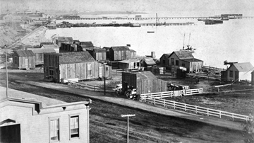 Historical photograph of San Diego Waterfront from 1888, showcasing ships, buildings, and the bustling shoreline.