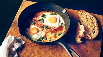Pan with sunny side up eggs cooked with toast on the side