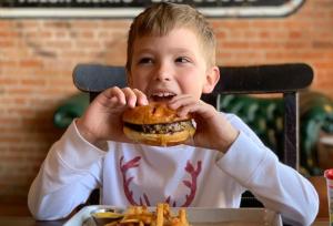 Boy eating burger at Local Yocal