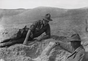 Roy Chapman Andrews, left, investigating a fossil bone from a massive rhinoceros-like mammal in the Gobi Desert in 1928