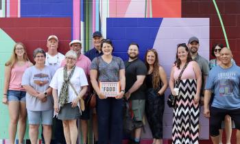 A tour group standing in front of a mural.