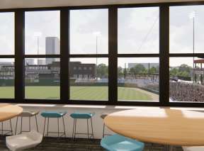 Small conference room with seating overlooking baseball game through glass windows