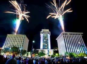 Crowd in downtown Wichita watching opening ceremony fireworks over Garvey Center and downtown buildings