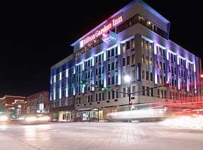 Hilten Garden Inn Downtown Wichita at night with traffic flowing in front of building