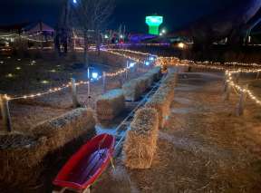 A sled sits between hay bales at the Holly Jolly Jurassic Holiday event at Field Station: Dinosaurs