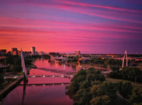 The sky is pink and blue above the Wichita skyline during sunrise