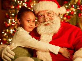 A young girl poses on Santa's lap during a holiday  market