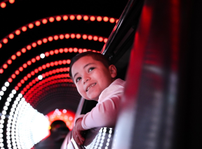 A boy looks out a car window as he looks at Christmas lights in a drive-thru tunnel at Tanganyika Wildlife Park