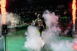 Lacrosse player running on stage with smoke around him