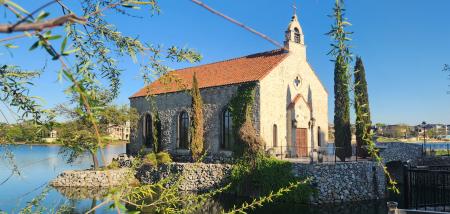 Chapel on an island in a lake with spring leafy branches in front