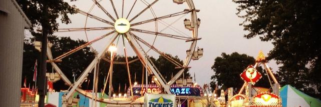 Crowd by food vendors and ferris wheel at the Monroe County Fair