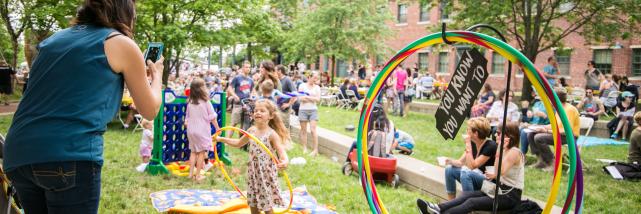 A mom taking a photo of her daughter hoola hooping at Taste of Bloomington