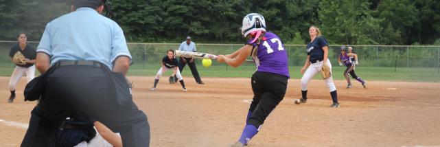 A batter hitting a softball during a game