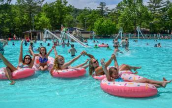 Knoebels Crystal Pool with Girls in Pink Floaties arms raised and smiles on their faces