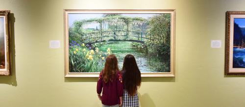 Two girls looking at a painting at R.W. Norton Art Gallery