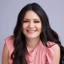 Christy Headshot - tan Caucasian woman with long, dark brown hair and brown eyes wearing light pink shirt