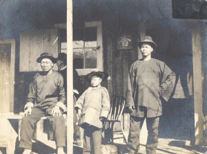 Photo of three men & child on porch. c 1898. Chinese New Year.