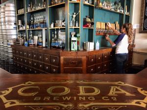 Coda Brewery - interior shot of bar, woman pouring tap beer