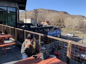Woman sips a drink on outdoor patio at Golden Mill Tasting Room