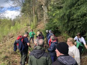 A ranger leads a group of walkers through the forest