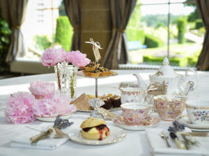 Afternoon tea in the Orangery at Weston Park, Staffordshire, with a beautiful table of fine bone china, scones and flowers, and a view into the wonderful gardens